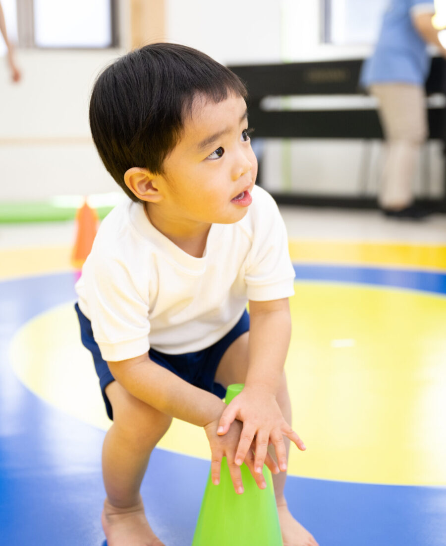 室内で運動をする子供たちと先生